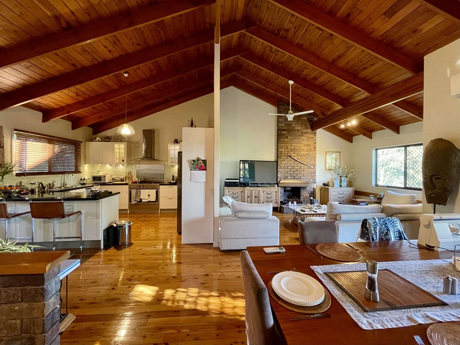 A kitchen lit by downlights and a pendant over the bench